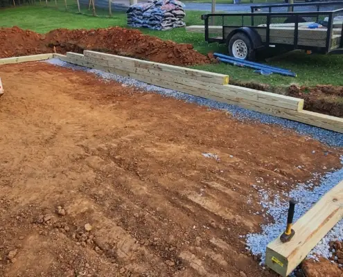 Leveled dirt pad framed with timbers for a backyard project