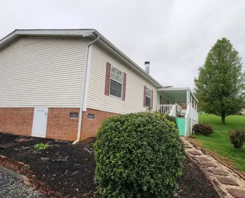 Mulched flower bed and paver walkway along a white home