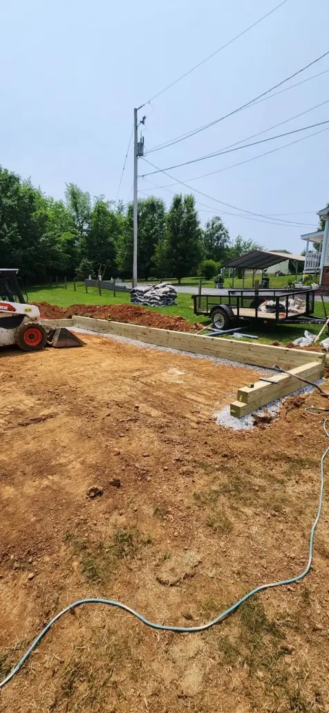 Timber border and leveled ground for a play area, with a skid steer
