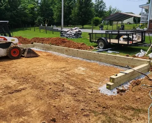 Timber border and leveled ground for a play area, with a skid steer