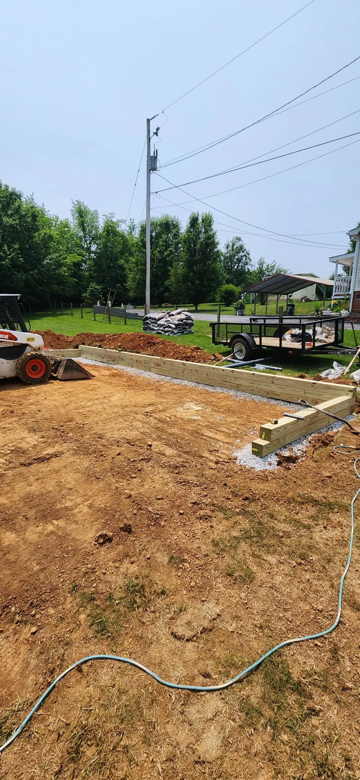 Timber border and leveled ground for a play area, with a skid steer