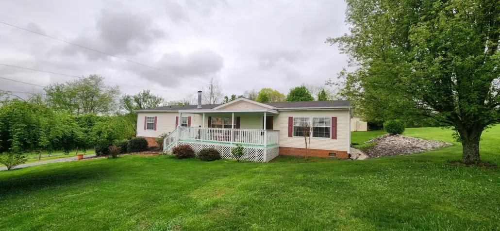 Mowed front lawn and trimmed shrubs at a white home