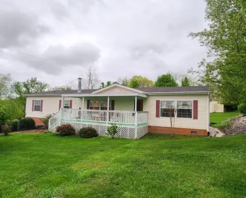Mowed front lawn and trimmed shrubs at a white home