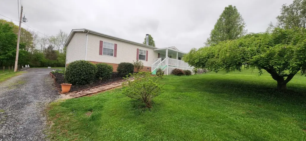 Mulched beds and stepping-stone path beside a white home