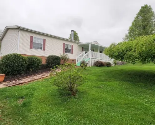 Mulched beds and stepping-stone path beside a white home