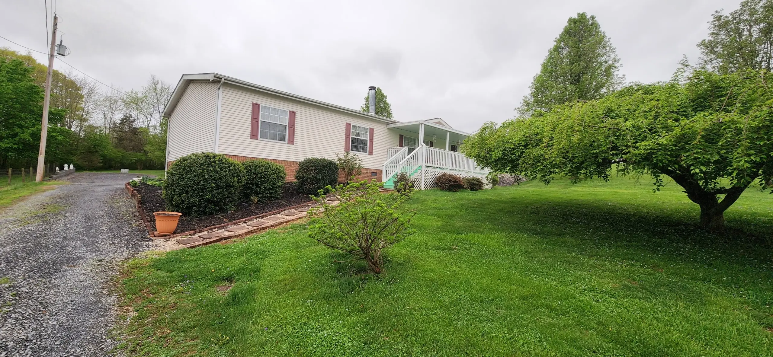 Mulched beds and stepping-stone path beside a white home