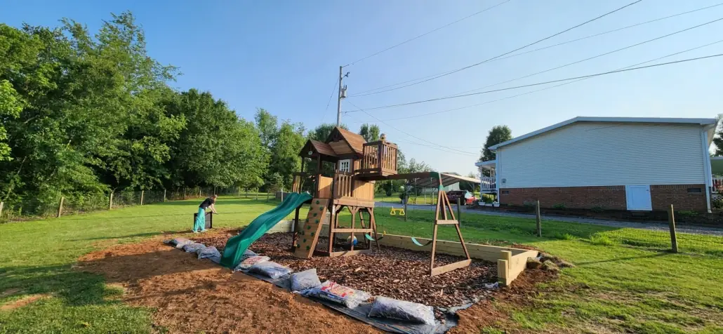 Wooden swing set installed on a new mulch play area