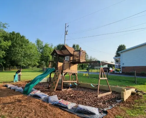 Wooden swing set installed on a new mulch play area