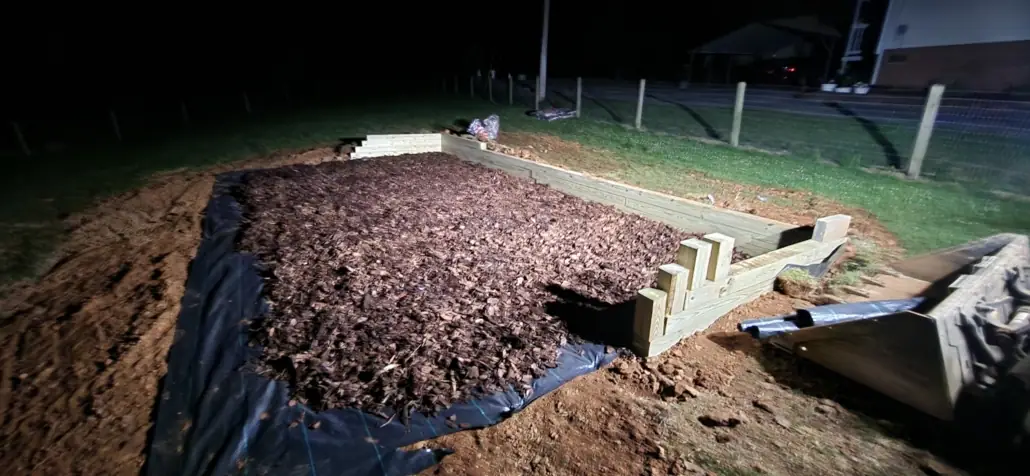 Timber-bordered mulch bed with steps at night