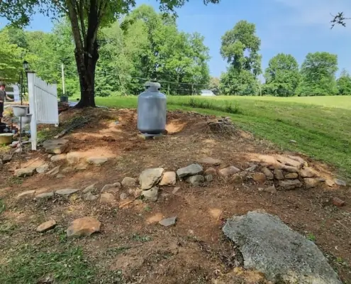 Hillside bed being cleared of weeds and stones