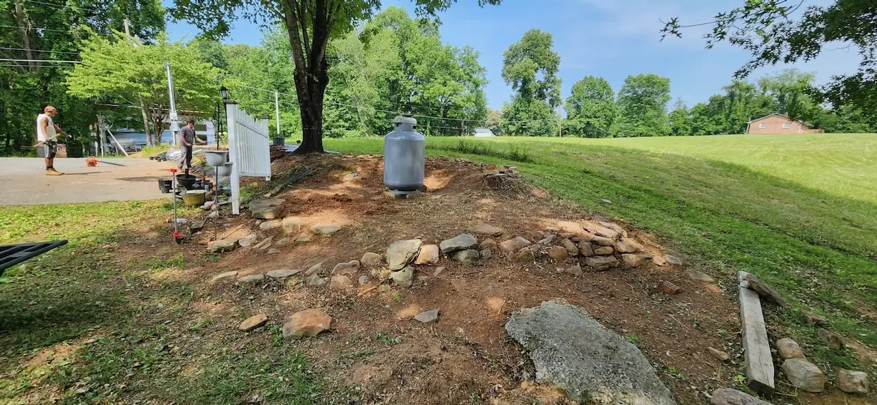 Hillside bed being cleared of weeds and stones
